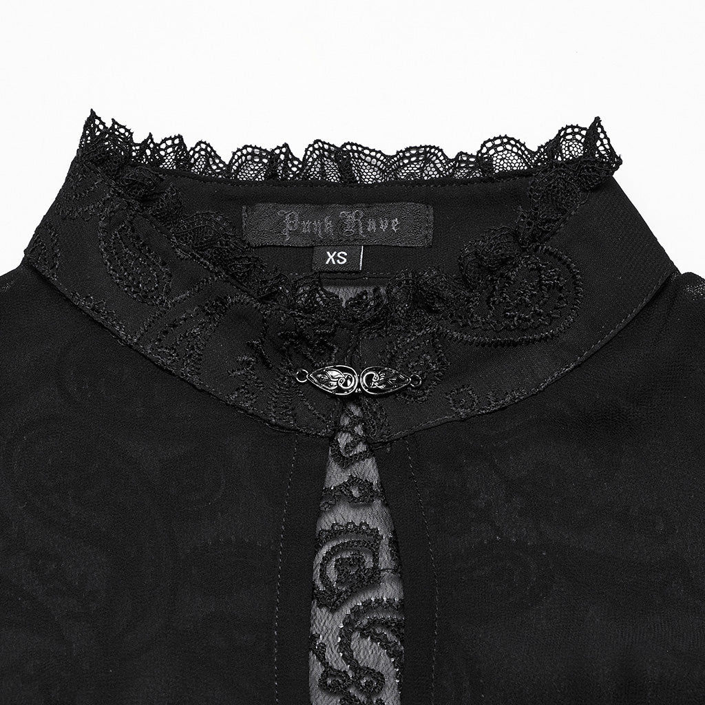 Detalle del cuello mao con volante de encaje y broche metálico sobre la abertura en gota