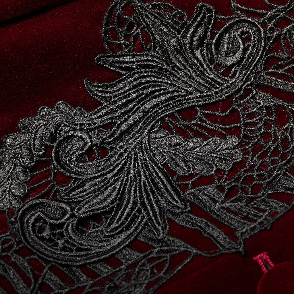 Detalle del aplique de encaje bordado negro sobre el terciopelo rojo