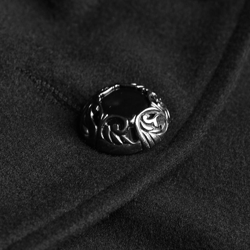 Botón metálico plateado labrado con centro negro del abrigo