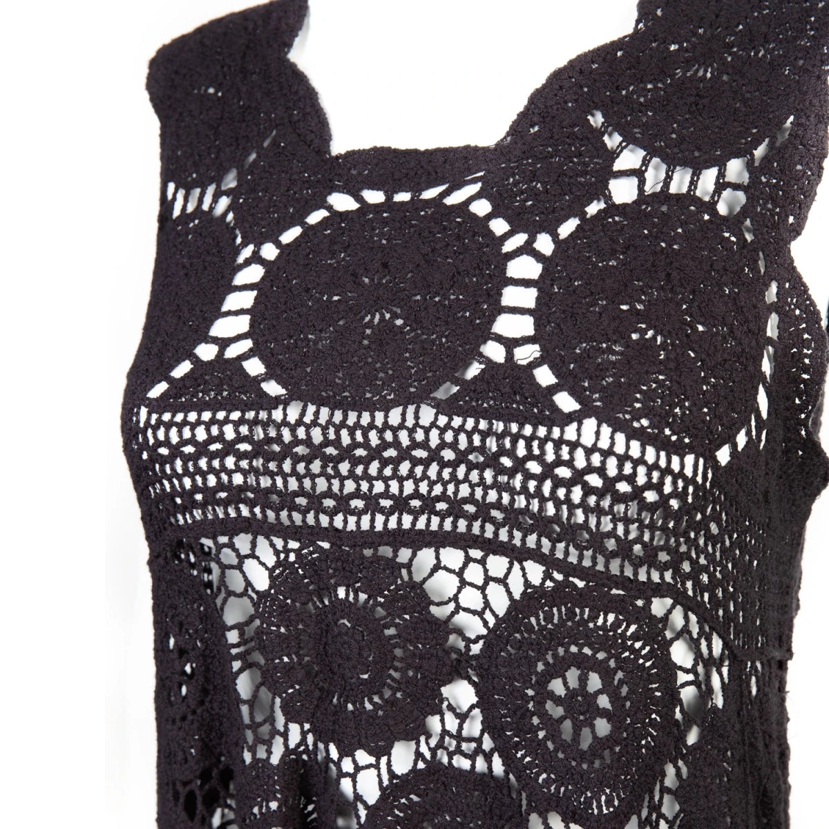 Close-up of the scalloped neckline and crochet medallions of the black vest