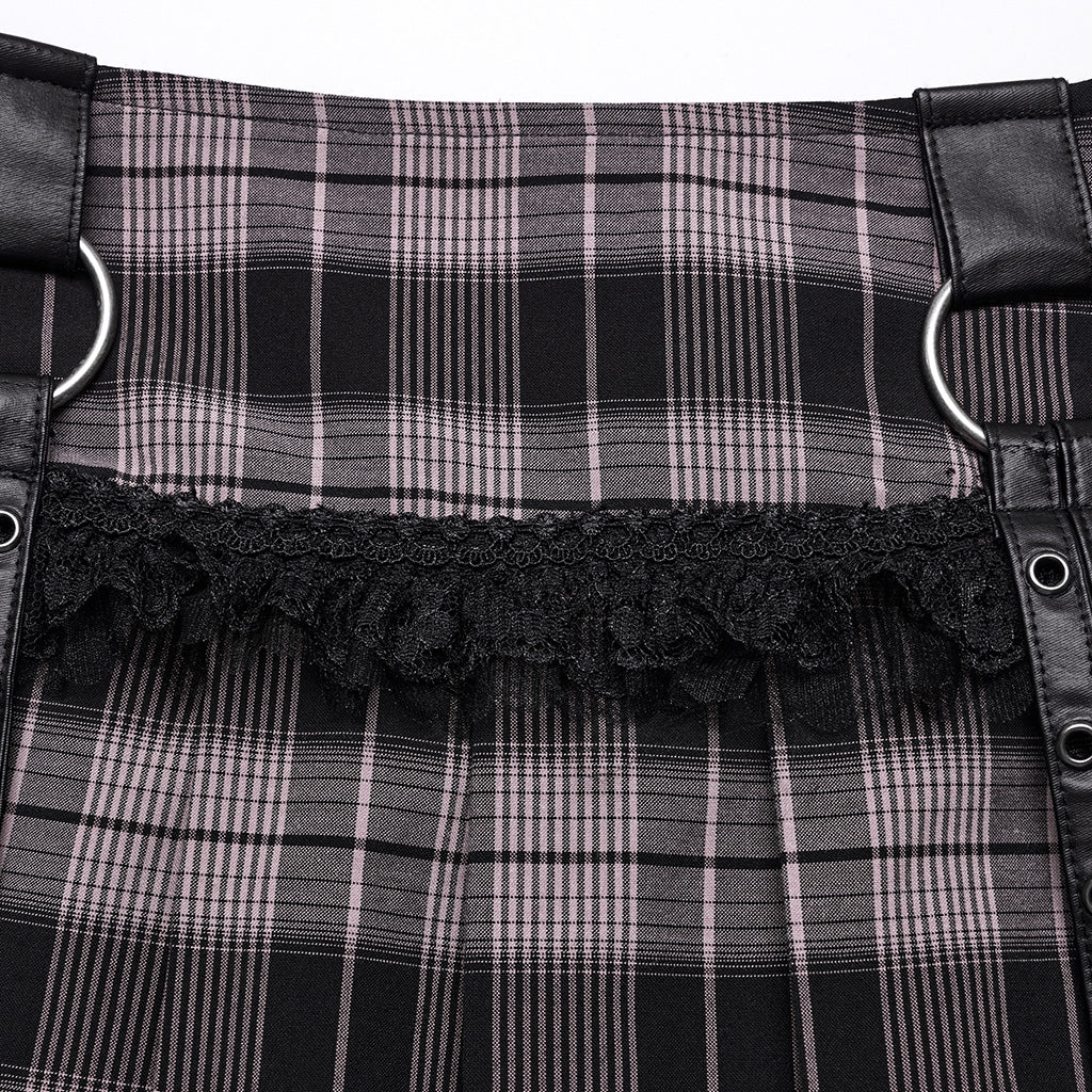 Detalle del tejido de cuadros rosa y negro con volante de encaje y trabillas con aro